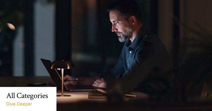 Man reading on his laptop at night
